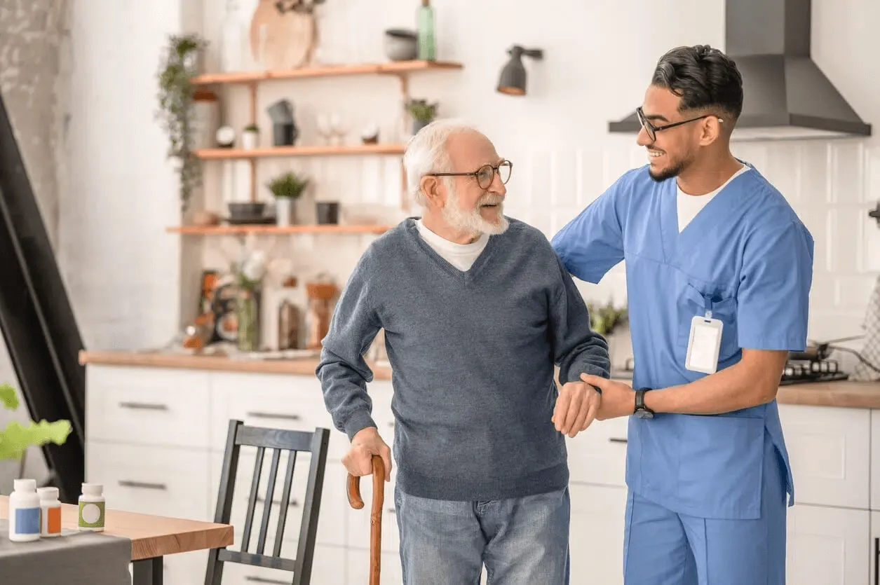 Profesional de la salud acompañando a un paciente mayor en su casa
