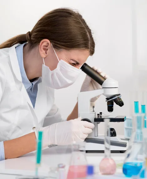 Bioanalista observando una muestra en el microscopio